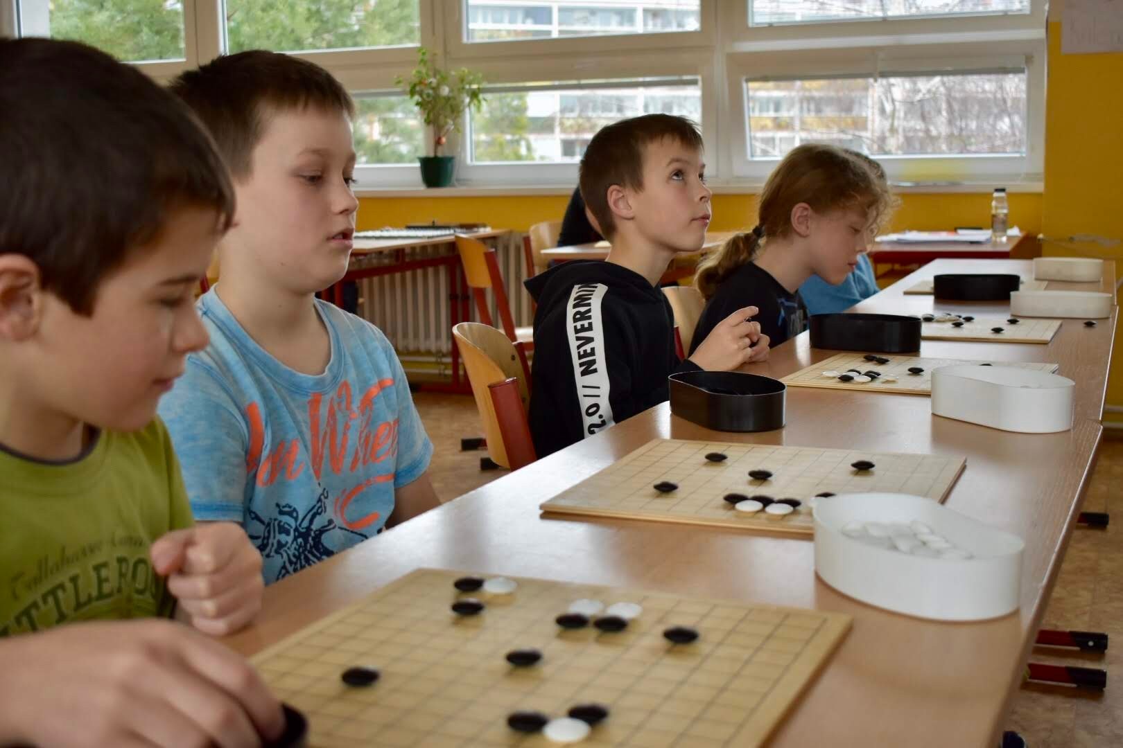 Děti hrají go na školních lavicích