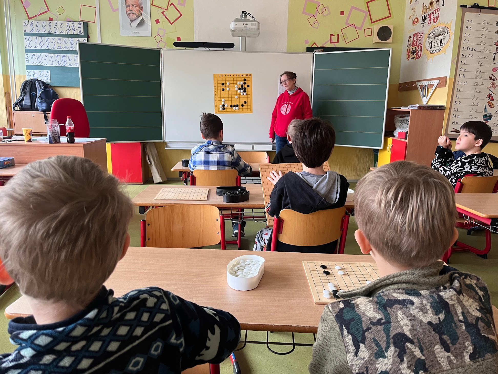 Lektorka vysvětluje strategii go u tabule